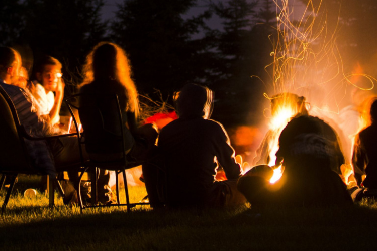 A group of people around a fire telling stories.